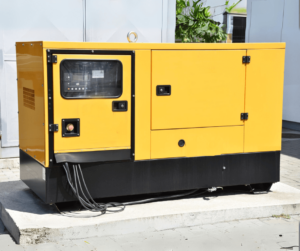 Black and yellow generator on a concrete platform on a building. 